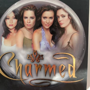 Charmed - Komplett DVD-box med säsong 1-8 - Säljer en komplett DVD-box med alla åtta säsonger av tv-serien Charmed. Boxen innehåller flera fodral med omslag där huvudkaraktärerna syns, samt individuella DVD-skivor för varje säsong. Perfekt för dig som vill samla hela serien hemma.