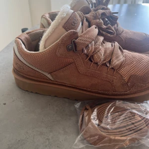UGG LOWMEL - Säljer ett  UGG lowmel i färgen chestnut. Skorna har snörning och kommer med extra skosnören har inte kartongen kvar.