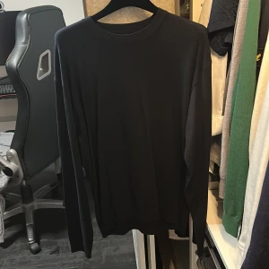 Svart långärmad tröja från ZARA - Säljer en stilren svart långärmad tröja från ZARA. Tröjan har en klassisk rund halsringning och är tillverkad i ett mjukt material som passar perfekt till vardags. Enkel och tidlös design som är lätt att matcha.