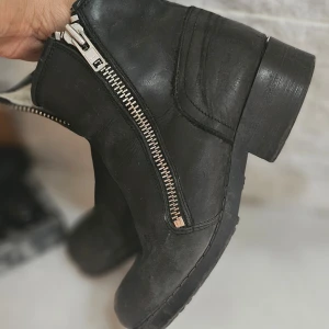 Svarta boots med dragkedja från Johnny bulls - Svarta boots i skinn med grov sula och silverfärgad dragkedja på sidan. Fodrade på insidan för extra värme och komfort. Perfekta till höst och vinter för en cool och stilren look.