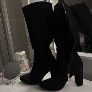 Svarta stövlar med klack - Snygga svarta stövlar med hög klack och dragkedja på sidan. Mocka material, storlek 39, aldrig använda, pris 300:- vid frågor kontakta mig 🫶🏽