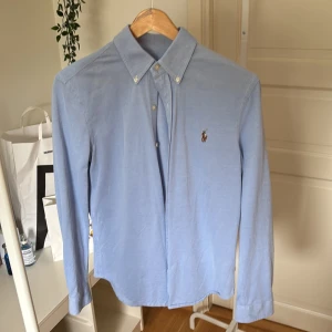 Ljusblå skjorta från Ralph Lauren S - Klassisk ljusblå skjorta från Ralph Lauren i bomull med broderad logga på bröstet. Skjortan har knappar hela vägen, button-down krage och lång ärm. Perfekt för en clean och stilren look. Nypris 1599kr storlek small herr