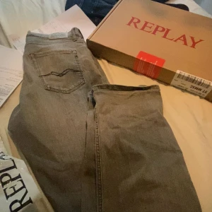 Replay grå jeans straight fit - Säljer ett par grå jeans från Replay i modellen Thad. Jeansen har klassisk femficksdesign, raka ben och snygga detaljer på bakfickan. Tillverkade i bomull för en skön känsla och stilren look. Perfekta till sneakers och hoodie. Modellen är Thad. Nypris: 800kr! Mitt pris 350kr🙌🏼 priset är inte hugget i sten hör gärna av er vid funderingar