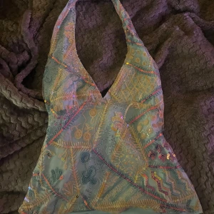 Paljett halterneck topp! - Turkos halterneck topp med färgglada paljetter!! Köpt på en marknad i spanien nypris: 500kr, säljer eftersom den inte kommer till användning, helt nyskick inga defekter❤️❤️ storlek S men skulle säkert passa nån som har M också❤️