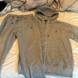 Grå hoodie från Polo Ralph Lauren - Säljer en grå hoodie från Polo Ralph Lauren med dragkedja och huva. Tröjan har snörning i huvan, broderad logga på bröstet och är tillverkad i mjuk bomullsmix. Perfekt för chill dagar eller när du vill ha en clean och enkel look.