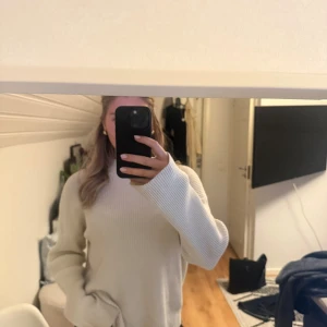 Vit ribbad stickad tröja - Säljer en vit ribbad stickad tröja med hög hals och långa ärmar. Tröjan har en loose fit och är perfekt för lager-på-lager. Den är enkel att matcha och har en clean vibe som funkar till allt.