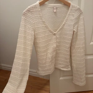 Vit stickad kofta från Nelly - Ny utan prislapp!! Vit stickad kofta från Nelly med v-ringning och vida långärmar. 