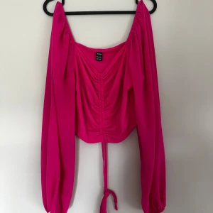 Rosa topp från SHEIN - Trendig rosa topp från SHEIN med långa puffiga ärmar och snygg snörning framtill. Toppen ribbad struktur