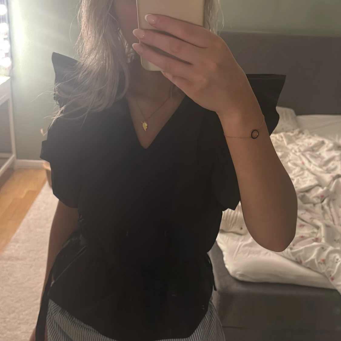 Svart blus med volangaxlar och knyt