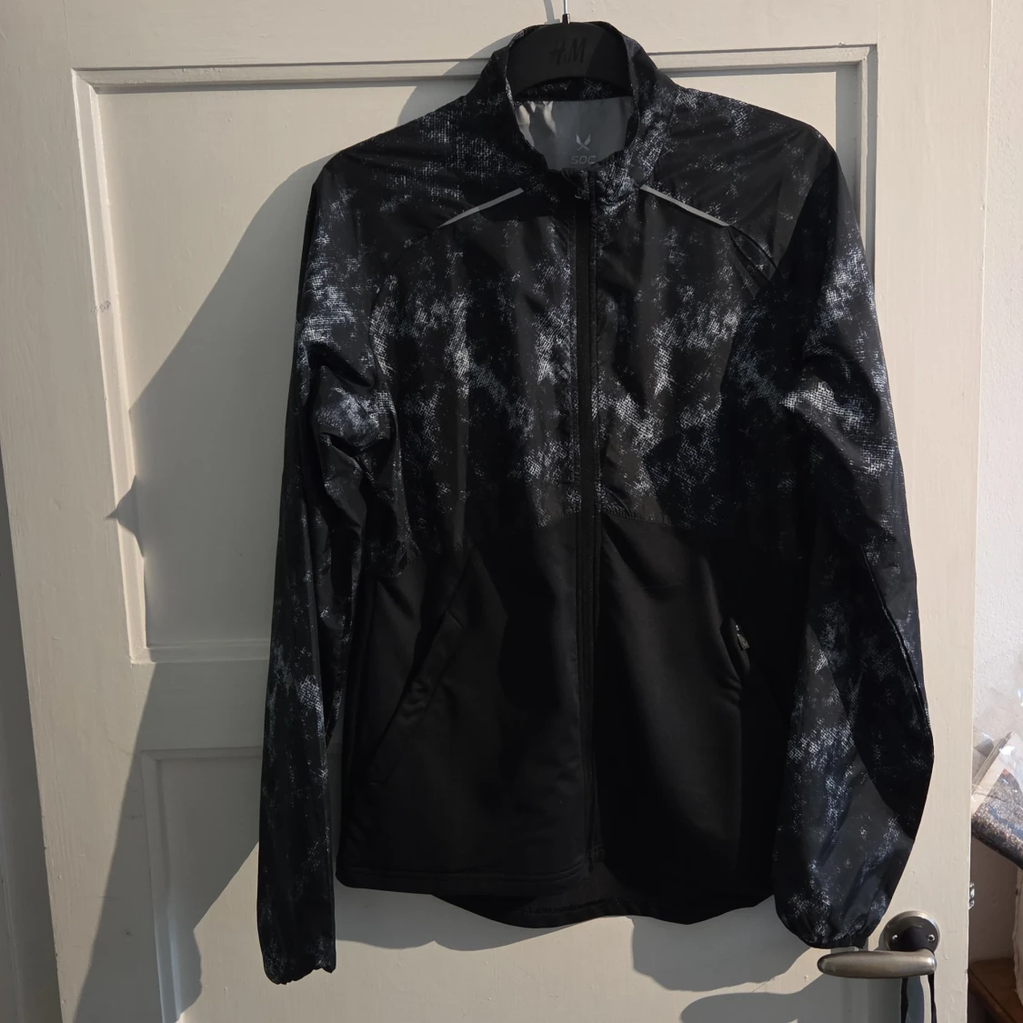 Svart vindjacka SOC med mönster