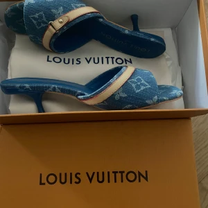 Louis Vuitton denim sandals with heels - Unique Louis Vuitton sandals in blue denim with the iconic monogram pattern. The shoes feature an open toe, low heel, and a beige leather detail with a buckle. A stylish contrast between blue and beige – perfect for anyone who wants to stand out with a touch of luxury.