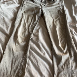 Grå jeans från Gina Tricot, stl 152 - Snygga grå jeans från Gina Tricot i modell med råa kanter nertill. Klassisk femficksdesign och knapp med logga. Perfekta för dig som gillar en avslappnad och trendig look.