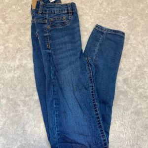 Blå Molly jeans från Gina tricot  - Snygga blå Molly jeans från Gina  jeans med klassisk femficksdesign och kontrastsömmar. Jeansen har hög midja och raka ben, tillverkade i mjukt denimtyg som sitter skönt hela dagen. Perfekta för dig som gillar en enkel och tidlös look.