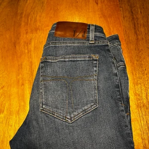 Tiger of sweden jeans  - Snygga mörkblå jeans från tiger of sweden med klassisk femficksdesign och kontrastsömmar. Jeansen har en rak passform och är tillverkade i slitstarkt denimtyg. Perfekta för dig som gillar en tidlös och enkel stil. Vid funderingar är det bara att kontakta mig jag är ärlig och rak med svar.