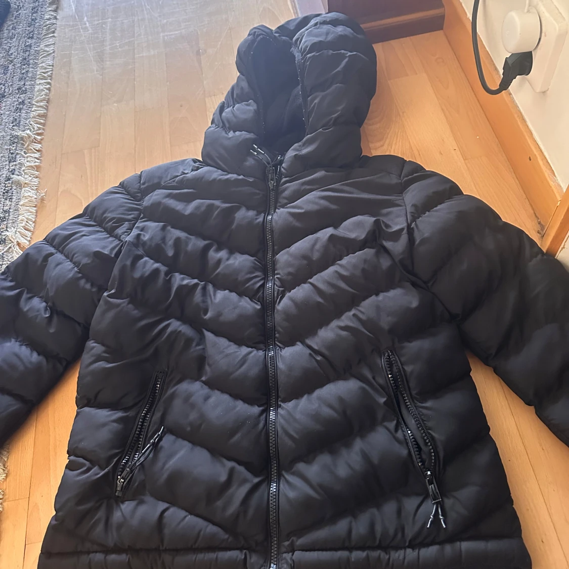 Svart pufferjacka med huva