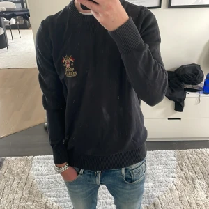 Svart stickad tröja från Morris - Snygg svart stickad tröja frpn Morris. Perfekt nu inför lite kallare tider. Modellen är ca 180cm. Hör av dig vid funderingar!