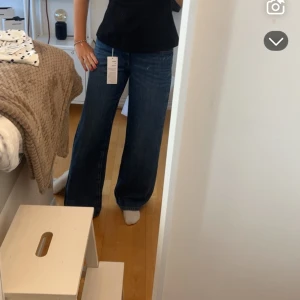 Mörkblå wide jeans med medellåg midja - Snygga mörkblå jeans med breda ben och hög midja. Klassisk femficksmodell i jeansmaterial, perfekt för en avslappnad och trendig look. Passar dig som gillar loose fit och vill ha en modern siluett! ☺️☺️
