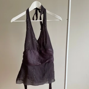 Halterneck topp med paljetter - Festtopp med paljetter och halterneck, skulle uppskatta till storlek S. Ingen lapp/märke. Använd 2-3 gånger, super skick. #halterneck #sequins #purple #trendy #swag #drainer #coquette #vintage #copenhagenstyle #style #bow 