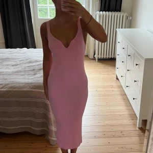Rosa ribbad långklänning från Dilvin - Säljer en superfin rosa långklänning från Ciquelle. Klänningen är ribbad, har en djup v-ringning och breda axelband. Den är figurnära och stretchig, vilket ger en snygg slim passform. Perfekt för dig som gillar en enkel men ändå trendig look.