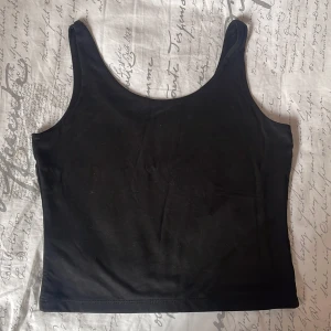 Svart linnetopp från Reserved XS - Enkel och stilren svart linnetopp från Reserved i storlek XS. Toppen har smala axelband och rak passform, perfekt att matcha med jeans eller kjol. Tillverkad i mjuk bomull som känns skön mot huden. Andvänd bara 1 gång!
