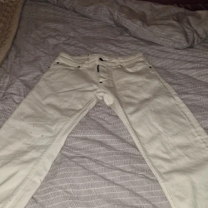 Vita jeans från Dsquared2 - Snygga vita jeans från Dsquared2 med klassisk femficksdesign och svarta detaljer vid fickorna. Jeansen är raka i modellen och tillverkade i bomull, perfekta för dig som vill sticka ut med en clean och fräsch look.