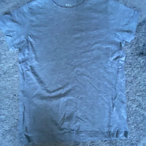 Grå t-shirt från lager 157, storlek 140 - En enkel och mjuk grå t-shirt från lager 157 i storlek 140. T-shirten har rund hals och korta ärmar, tillverkad i 95% bomull och 5% viskos för skön känsla. Perfekt för chill dagar och passar till allt. Snygg basic som funkar året runt.
