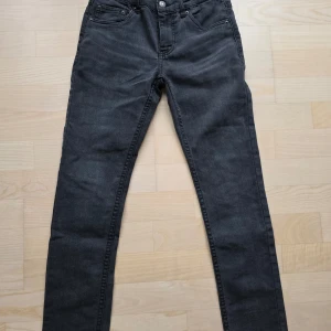 Levi's 512 svarta skinny jeans 152 cm - Snygga svarta Levi's 512 jeans i skinny fit med klassisk femficksdesign och diskret logga på bakfickan. Jeansen är i stretchigt denim och passar dig som gillar en smal siluett. Perfekta till sneakers..