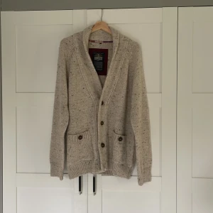 Stickad kofta.  - Beige stickad kofta från Hampton Republic med bruna knappar och två fickor framtill. Koftan har mörkbruna armbågslappar. Koftan är nästintill oanvänd. Priset kan förhandlas vid snabb affär 