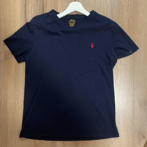 En snygg mörkblå tröja från Ralph Lauren - Snygg mörkblå stickad lång tröja från Ralph Lauren i bra skick | Storlek: S | Mitt pris: 89kr | Seriösa köpare enbart | Har du några frågor är det bara att meddela| OBS, den har ett par små vita fläckar på den men annars är den i mycket bra skick|