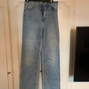 Stradivarius ljusblå wide jeans, stl 34 - Snygga ljusblå jeans från Stradivarius i storlek 34. Modellen har hög midja och raka, breda ben för en chill och trendig look. Klassisk femficksdesign och tillverkade i jeansmaterial med ljus tvätt. Perfekta att matcha med sneakers eller boots.