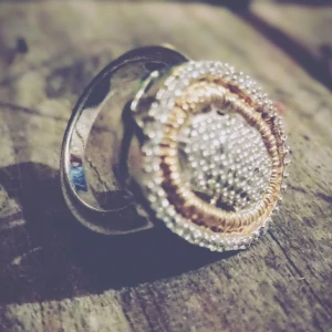 Oval ring i silver och guld - Snygg och unik ring med en stor oval form. Ringen har en glittrig yta i mitten omgiven av detaljer i både silver och guld. Perfekt för att ge en extra touch till din stil.