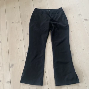 Svarta byxor från BikBok - Snygga svarta byxor från BikBok i storlek 36. Byxorna har en klassisk bootcut-stil och är tillverkade i ett mjukt material. De har hällor för bälte och stängs med dragkedja och knapp framtill.