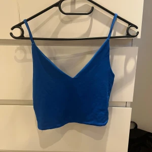 Blå topp - Blått linne från New yorker, använt en gång! Kort modell och glansigt, ganska tjockt material. Skriv för fler bilder eller frågor!💓