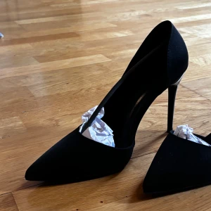 Svarta pumps med spetsig tå - Eleganta svarta pumps med spetsig tå och hög klack. Perfekta för en stilren look.