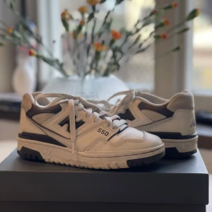 New Balance 550 sneakers - Snygga New Balance 550 sneakers i vitt med mörkgrå detaljer. Skorna har en klassisk design med snörning och sköna att gå i! Annvända sparsamt, köpt för 1200 på Arket.