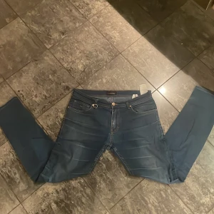 Blå jeansbyxor reaplay  - Snygga blå jeansbyxor med en klassisk femficksdesign och knappgylf. Perfekta för en avslappnad stil. De har en normal passform och är tillverkade i ett slitstarkt denimtyg.