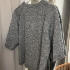 Grå stickad tröja - Säljer en mysig grå stickad tröja med trekvartsärm. Perfekt för kyliga dagar och enkel att matcha med olika outfits. Tröjan har en avslappnad passform och är gjord i ett mjukt material. Säljer då jag har för många liknande! Pris är disskuterbart 
