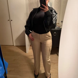 Beige cargopants med fickor från nakd - Snygga beige cargo kostym byxor med hög midja och raka ben från nakd. Byxorna har praktiska fickor på sidorna och en stilren design som passar perfekt till både vardag och mer uppklädda tillfällen. Perfekt för dig som vill ha en trendig och bekväm look. Endast använd ett fåtal gånger, pris kan diskuteras 🫶🏼💕