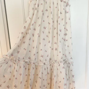 Blommig klänning med volangdetaljer - Idyllisk sommarklänning med blommor och volang! I strl xs & passar även s då man kan knyta vid halsen själv! 