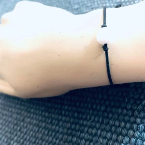 Made by prisförslag- Svart armband med glänsande vit pärla - Elegant armband med en vit pärla på en tunn svart tråd. Perfekt för en minimalistisk stil och passar till alla tillfällen. Enkel och stilren design som ger en subtil touch av elegans.