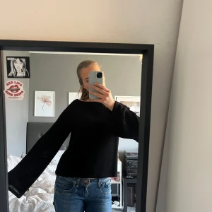 Svart stickad tröja - Säljer en stilren svart stickad tröja med långa vida ärmar. Passar till allt, tyget sticks inte heller. Väldigt bra skick, använt kanske 2 ggr.