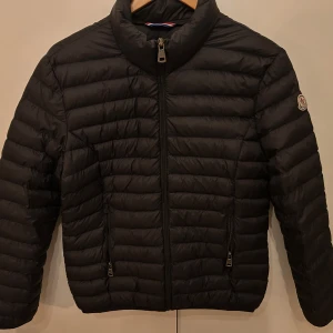 Svart dunjacka från Moncler - Snygg svart dunjacka från Moncler med dragkedja framtill och två fickor med dragkedjor. Om ni vill ha fler bilder är det bara att skriva. Den är i väldigt bra skick. 