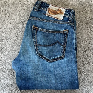 Blå jeans från Jacob Cohën - Skick: 9/10, lappen har förlorat lite tyg - Storlek: 32 - Längd:100cm Midja:41cm ben:18cm - Nypris: 5000 kr+