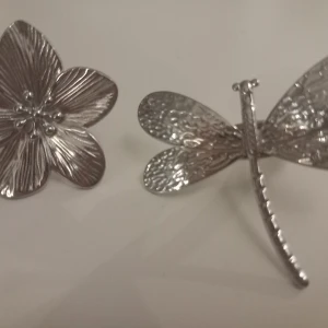 Silverfärgade ringar  - Två silverfärgade ringar, en som är en blomma och den andra en trollslända. Båda är justerbara för att passa olika storlekar. Säljer båda som ett set för 50 kr 🩷