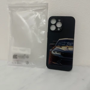 Svart mobilskal med bilmotiv för iphone 14 pro max - Snyggt svart mobilskal med ett coolt bilmotiv på baksidan. Skalet har utskärningar för kameran och knapparna, vilket ger enkel åtkomst till alla funktioner. Perfekt för bilentusiaster som vill ge sin telefon en sportig look.