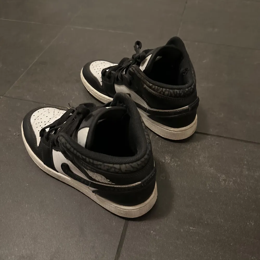 Snygga Nike Air Jordans i klassisk svart och vit färgkombination. Skorna har en ikonisk design med snörning och den välkända Nike-loggan på sidan. Perfekta för dig som vill ha en stilren look. Köpta på foot locker för 1500kr, såklart äkta stilrena fint sick har en liten skada uppe i sulan men sysn inte när skon är på, är det några frågor är det Bara att komma i dm 🔥✅💯. Kengät.