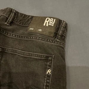 Svarta jeans från Replay - Snygga svarta jeans från Replay med klassisk femficksdesign och knappgylf. Perfekta för en stilren look. Märkesdetaljer på baksidan ger en extra touch. Bra skick. Slim fit säljes pga för små för mig. 30/30.