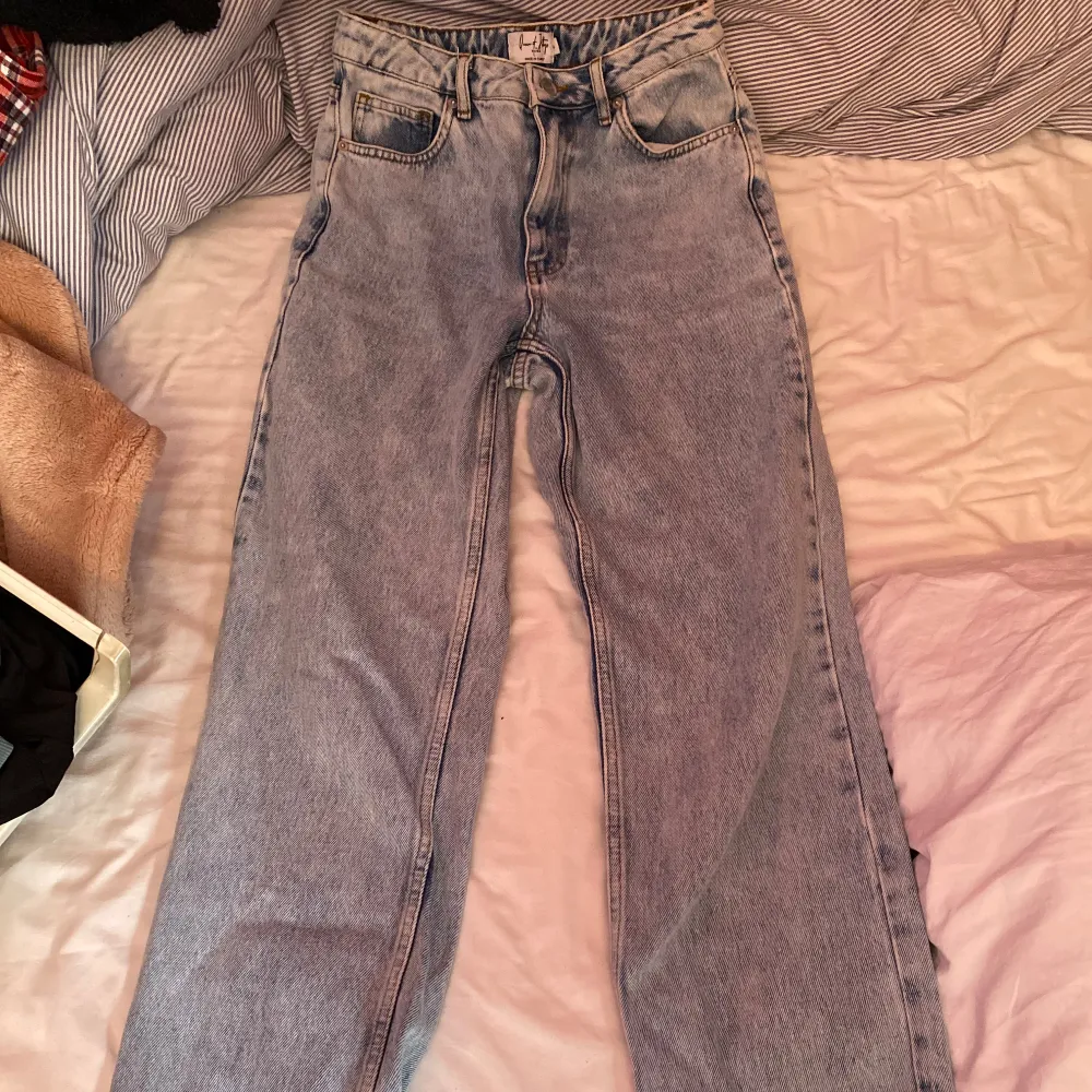 Säljer ett par snygga blå jeans från NA-KD. De har en hög midja och en straight passform. Stl 34 och knappt använda! Innerbenslängden är 76cm. Farkut & Housut.