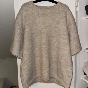 Beige stickad tröja - Mysig beige stickad tröja med korta ärmar. Perfekt för lager-på-lager under kyligare dagar. Har kommit till användning kanske en gång så är i väldigt bra skick🙏🩷