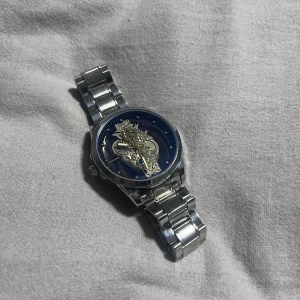 Snygg oanvänd klocka i stainless steel  - Stilren klocka med öppen urtavla så man ser det mekaniska i klockan. Helt oanvänd och den är i rostfritt stål. Skriv vid frågor 